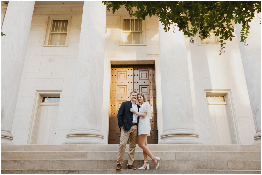 couple stand on steps of bank building