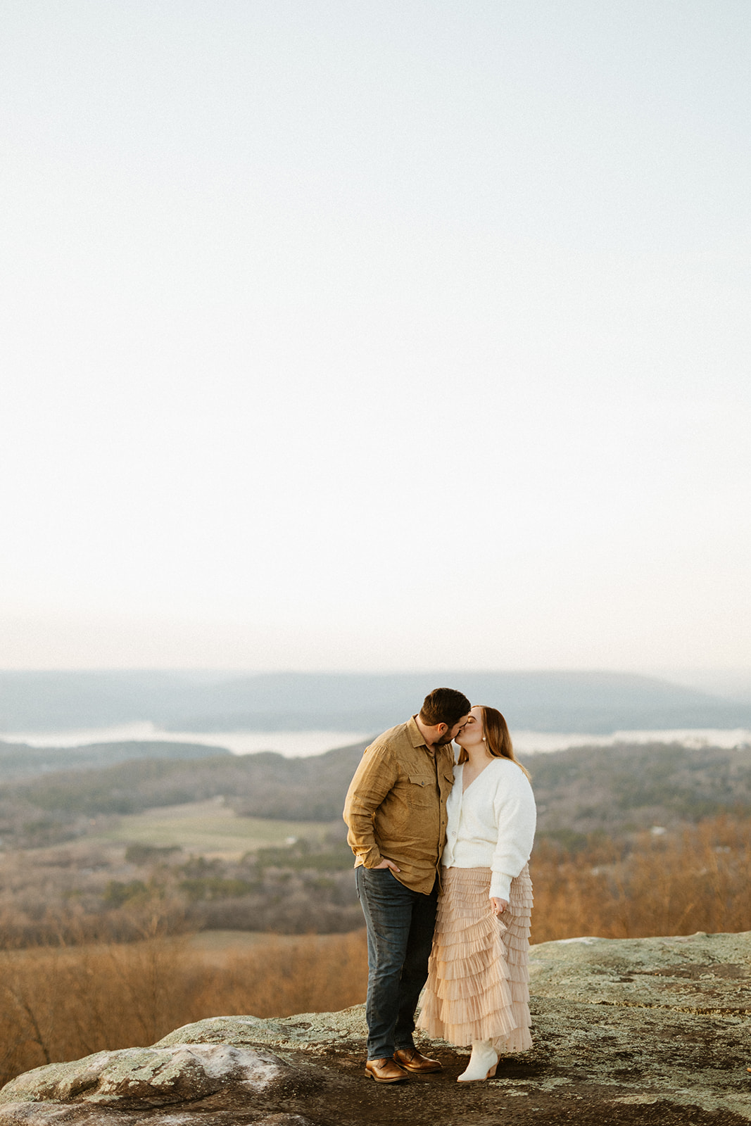 couple kissing on the edge of rock cliffs