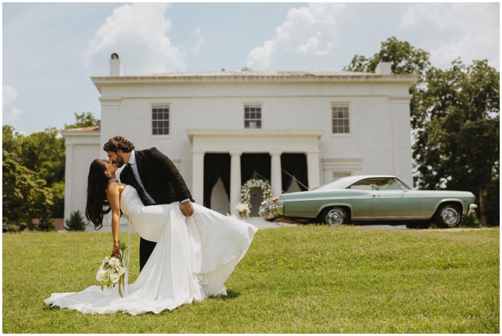 bride and groom kissing in front of vintage car
