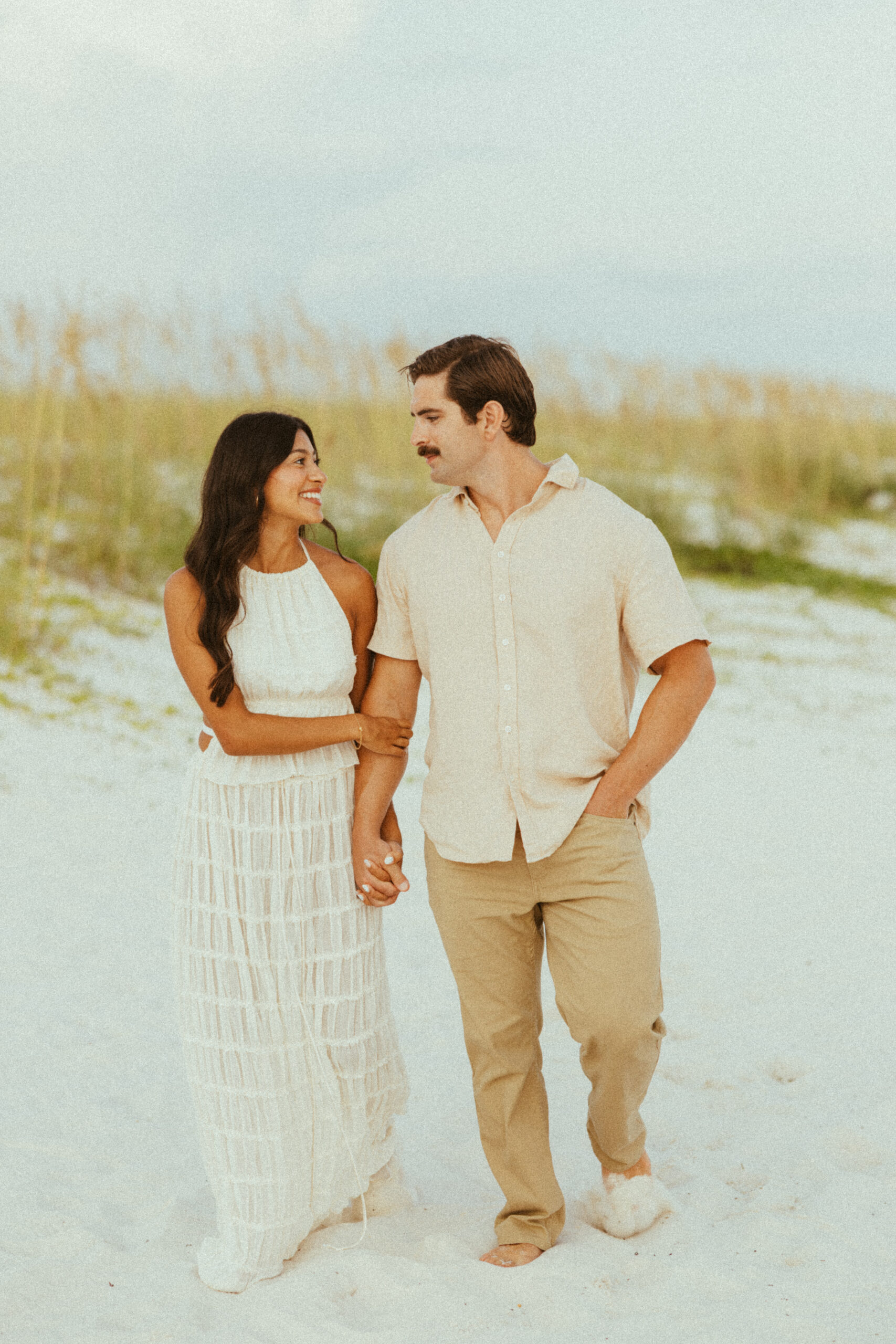 couple walking along shoreline at the beach