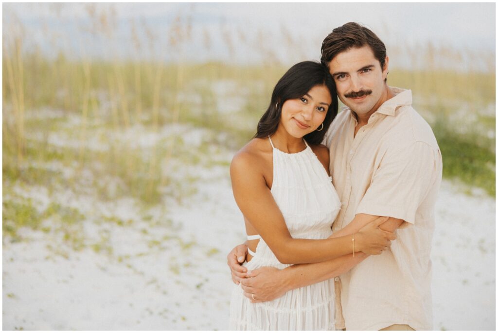 couple on beach smiling at the camera